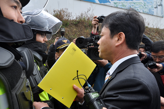 강경식 의원이 해군제주기지사업단 앞을 가로막는 경찰들에게 항의하고 있다.