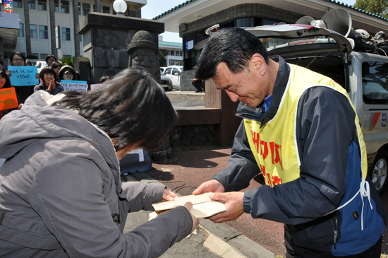 안산환경운동연합 관계자가 강동균 강정마을 회장에게 후원금을 전달하고 있다.