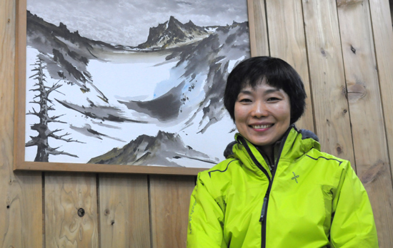 제주산악안전대 오경아 대장이 매장에 걸린 산악인이자 화가인 안흥찬 화백의 그림 앞에서 포즈를 취하고 있다. 오 대장은 전국 최초로 산악구조대 여성 대장이라는 한국 산악사에 새 역사를 쓰고 있다.