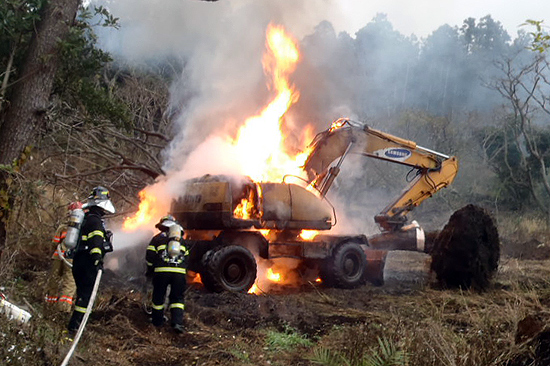 나무 심기 작업을 하던 굴삭기가 불에 타고 있다.